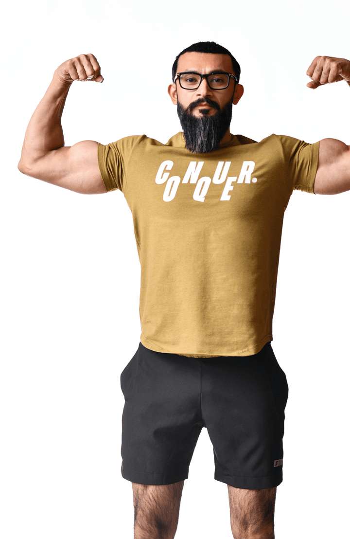 A bearded man wearing a gold t-shirt, showcasing a casual and stylish appearance.