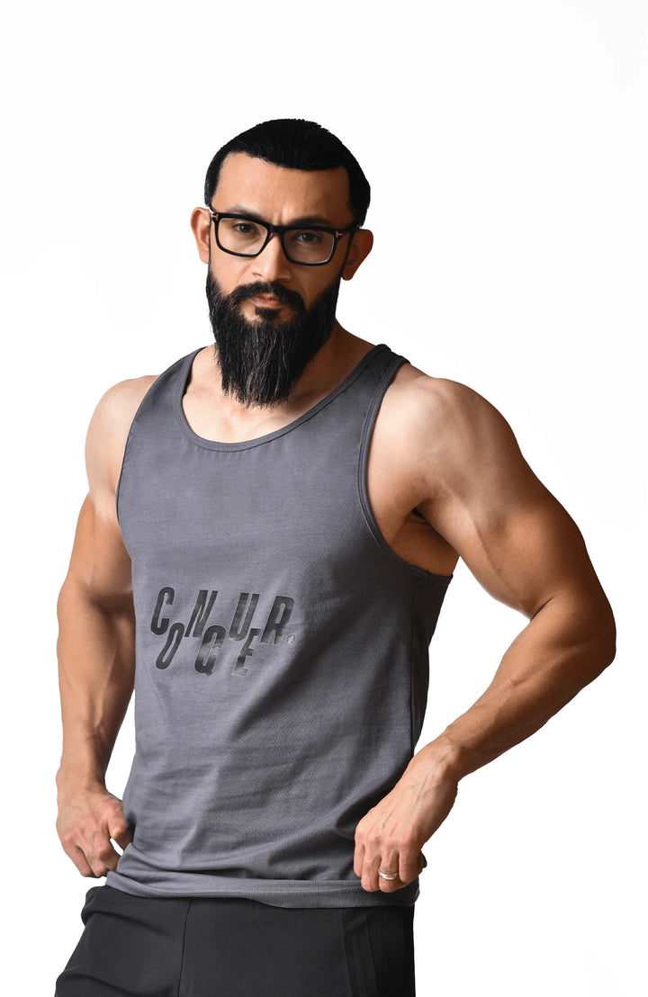 A bearded man wearing glasses and a tank top, showcasing a casual and relaxed appearance.