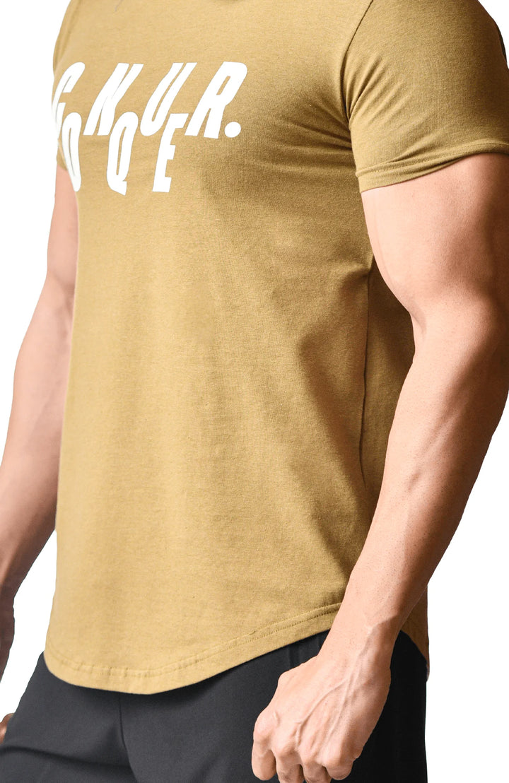 A bearded man wearing a gold t-shirt, showcasing a casual and stylish appearance.