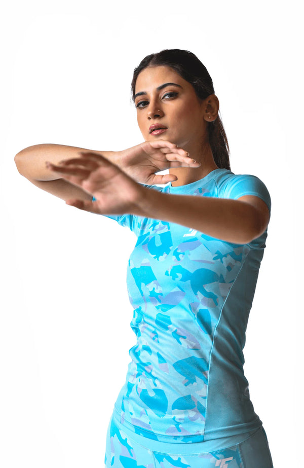 A woman dressed in blue and white clothing executes a handstand, demonstrating impressive athleticism and control.