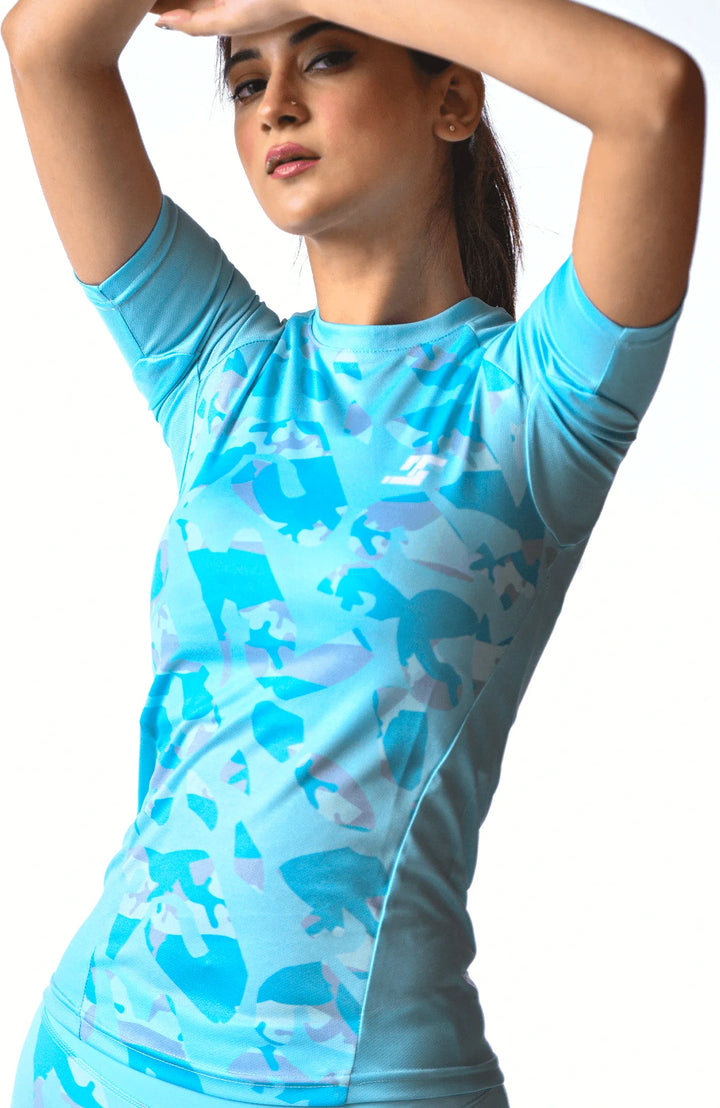 A woman dressed in blue and white clothing executes a handstand, demonstrating impressive athleticism and control.