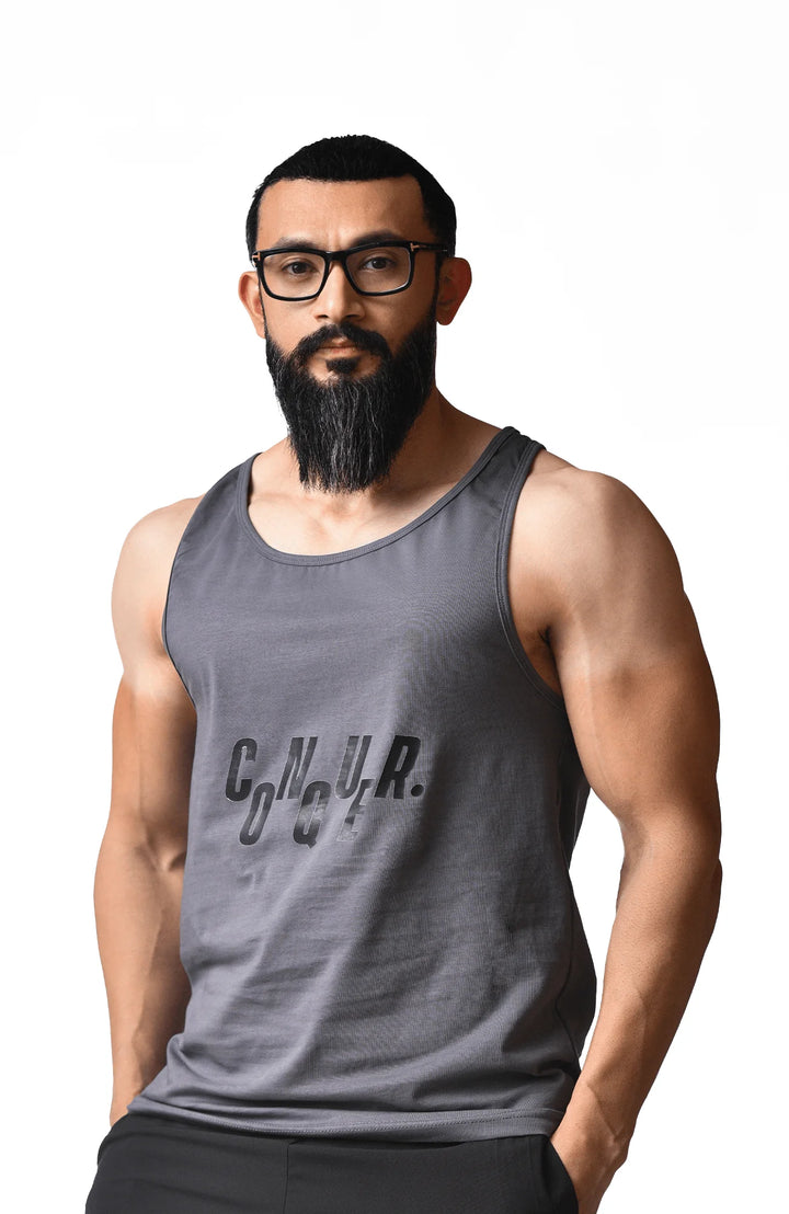 A bearded man wearing glasses and a tank top, showcasing a casual and relaxed appearance.